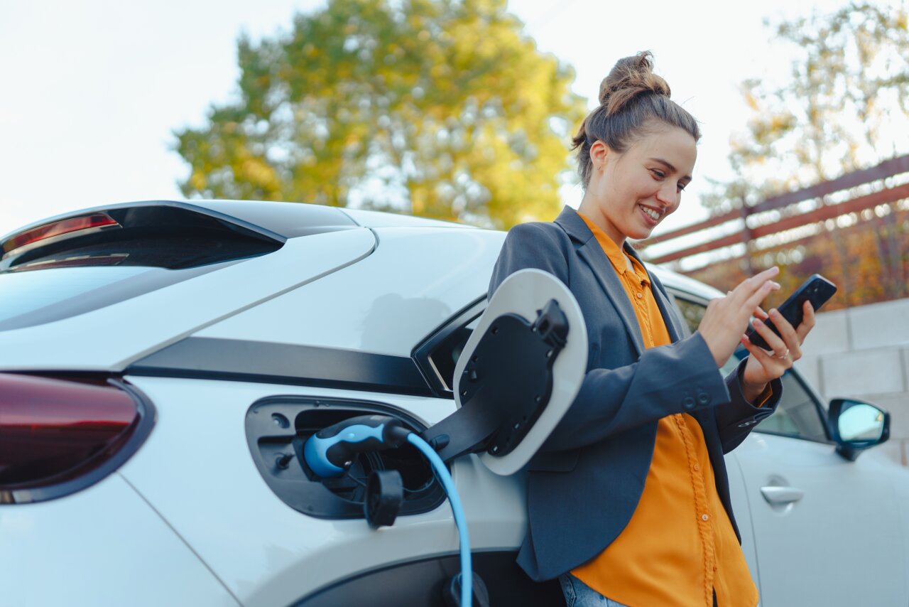 Frau lädt ihr E-Auto